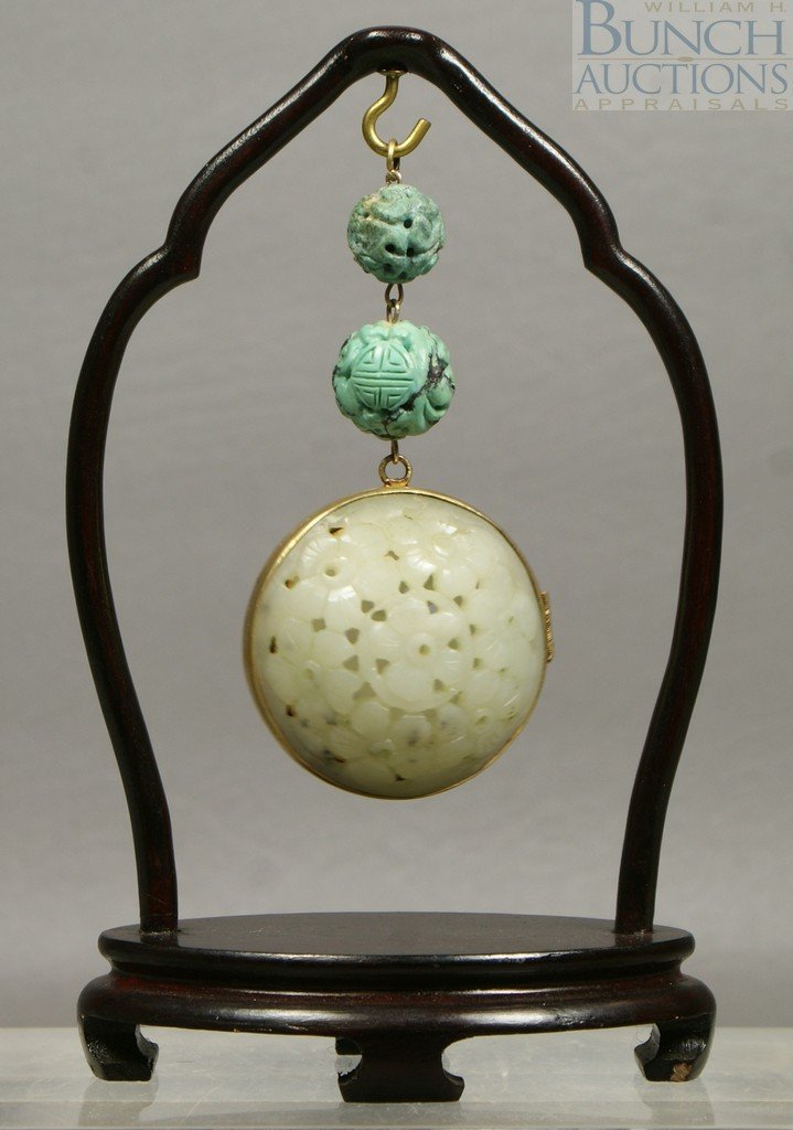 Floral carved jade locket suspended from 2 carve: Floral carved jade locket suspended from 2 carved turquoise balls on a hardwood frame, 6 1/4" tall overall