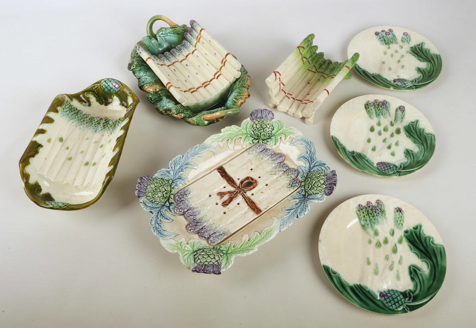 A Collection of French Majolica Asparagus Trays: A collection of French Majolica asparagus trays to include a double handled leaf formed Creil et Montereau tray with curved and modeled asparagus center, 15"L x 11"W, early 20th C., a Sarreguemines as