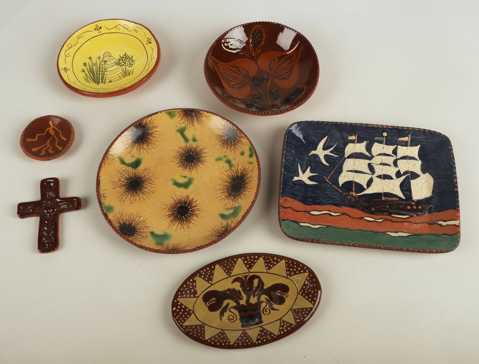 (7) Pieces of redware pottery: (7) Pieces of redware pottery, including 1990 Foltz Pottery floral bowl with coggled edge (7" dia x 1-5/8" h), Pam Armbrust sgraffito beehive plate (6-1/2" dia), Turtlecreek Potters tray with sailing