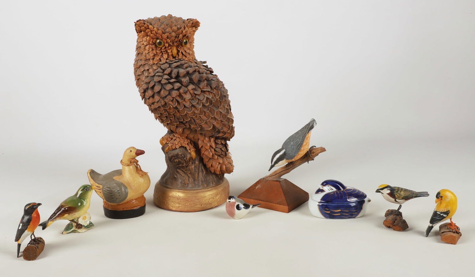 (9) Bird figures: (9) Bird figurines, including plaster owl covered in pinecone scales (13" h), carved & painted wood Nuthatch signed "John C Anderson Bristol RI 2000" (5-3/4" h), redware duck with impressed deer mark
