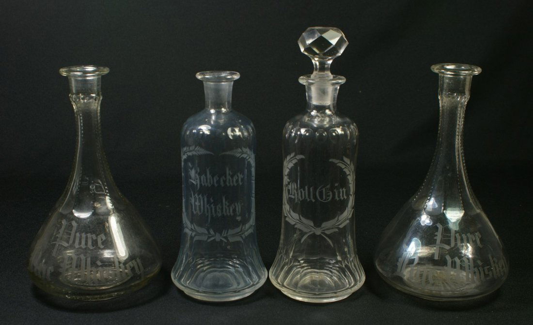 4 clear glass back bar bottles with etched decor: 4 clear glass back bar bottles with etched decoration, ROLL GIN, ROBECKER WHISKEY, PURE RYE WHISKEY, PURE RYE WHISKEY, tallest 11", three missing stoppers, chippage on bottom of stopper
