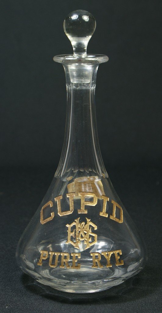 Clear glass back bar bottle with etched and gilt: Clear glass back bar bottle with etched and gilt decoration, CUPID PURE RYE, from Elias Hyman & Son, Cincinnati, 9 1/2", no damage