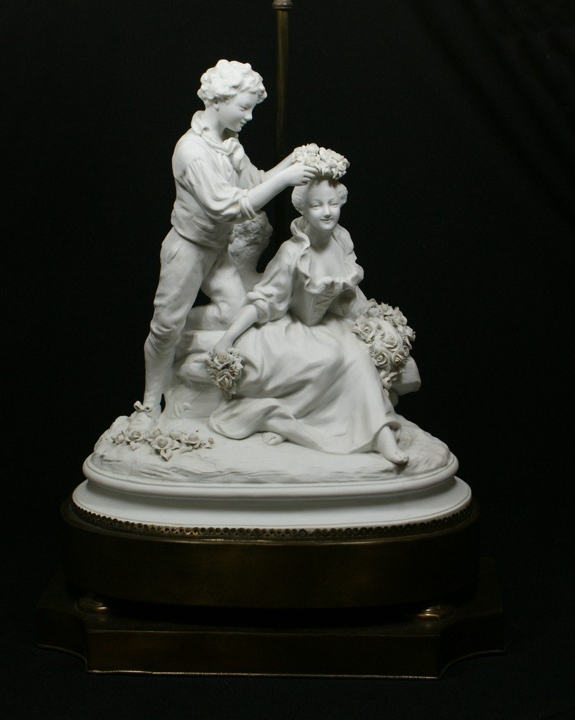 Schierholz Parian porcelain figural group young boy pla: Schierholz Parian porcelain figural group young boy placing a garland of flowers on girls head, blue underglaze pitchfork mark, incised title, the figure 14 1/2" tall, 13 1/4" w