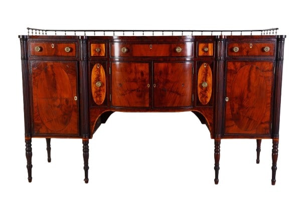 Federal style mahogany sideboard: Federal style mahogany sideboard, ebonized gallery supported by brass stanchions, beautiful crotch mahogany top, curved front, center drawer, flanked by (2) small drawers, over (2) doors, concealing l
