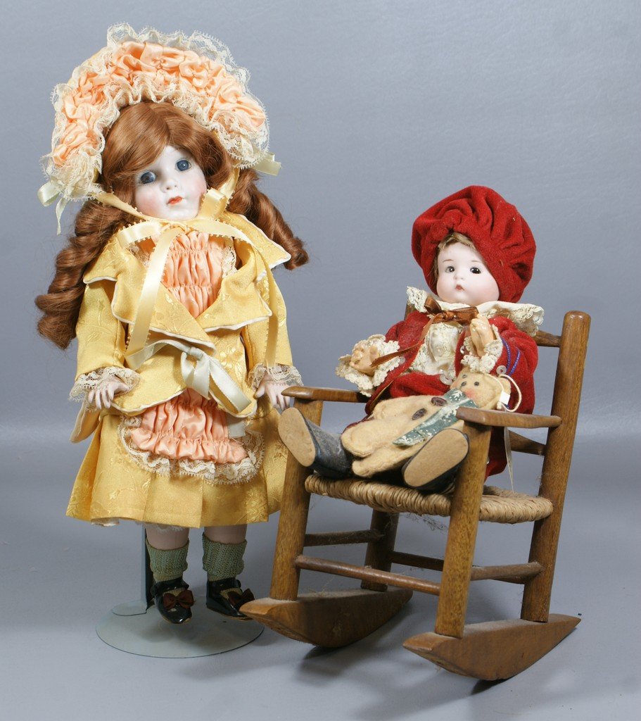 2 German Reproduction Character Dolls, the larger is a : 2 German Reproduction Character Dolls, the larger is a replica of a "Grace Corry Rockwell" and the smaller a copy of "Just Me" he is seated in an antique rocker with wicker seat, Rockwell doll has bre