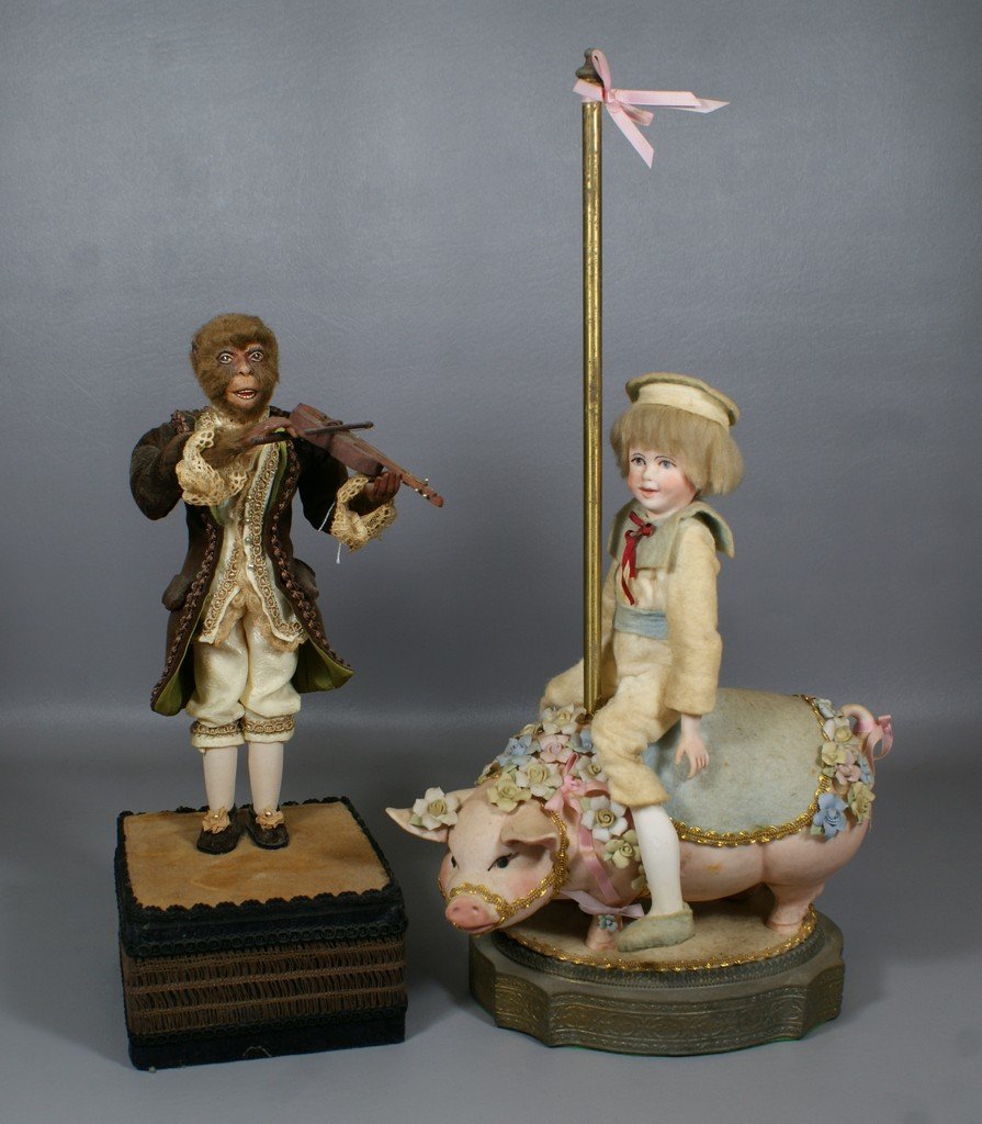 2 Artist Made Music Boxes, one Mounted on Lamp Base con: 2 Artist Made Music Boxes, one Mounted on Lamp Base consisting of a carousel bisque pig with seated articulated all bisque boy doll, key-wind music box in base, together with a monkey violin player wi