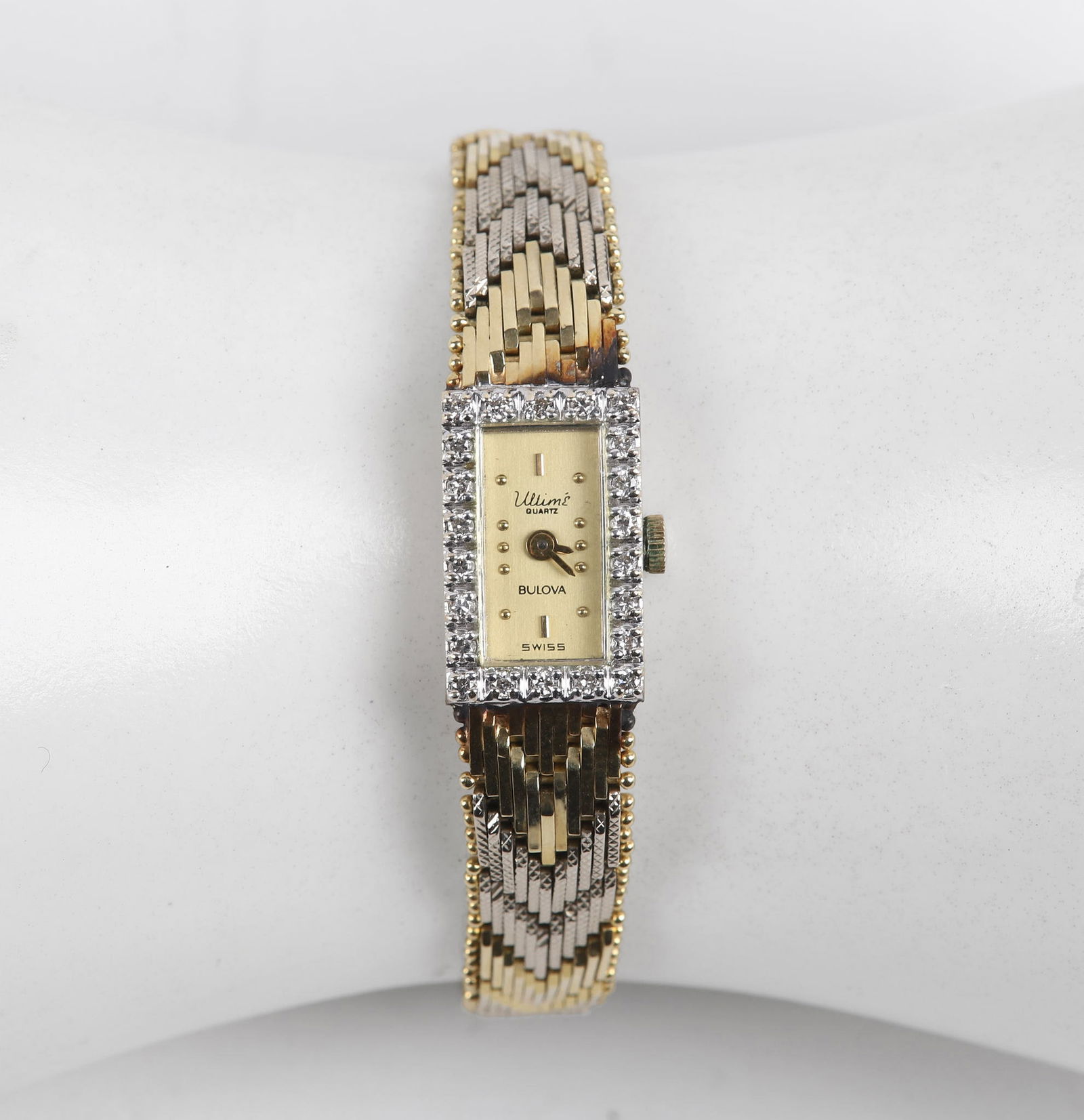14K Ladies Diamond Bezel Bulova Bracelet Watch: 14K Ladies Diamond Bezel Bulova Bracelet Watch, Bulova Ultime quartz signed dial, the bezel in (24) .8 mm diamond trim on textured chevron bead edge bracelet, 290.001 unadjusted 5 jewels signed Swiss,