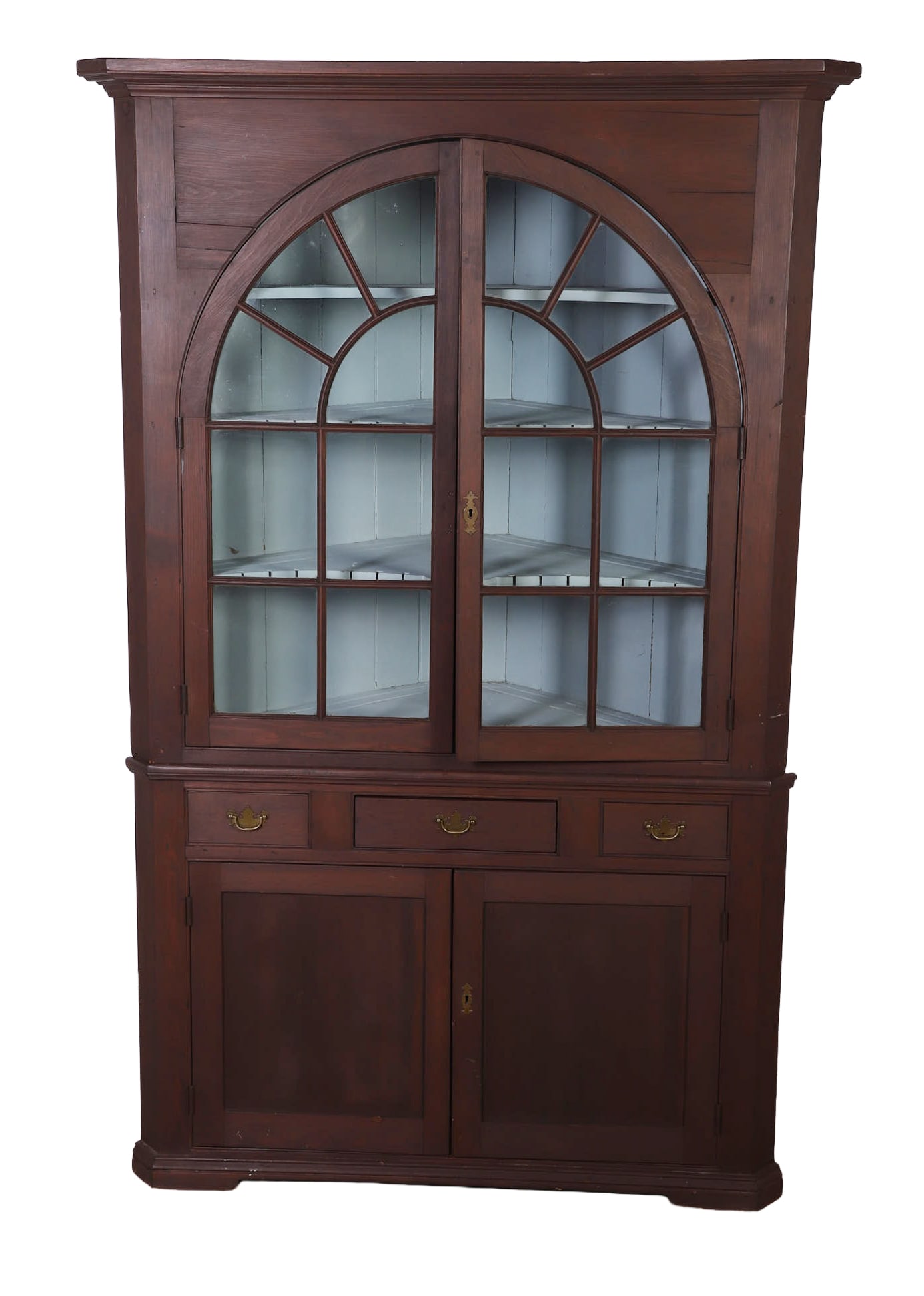 Softwood Mahogany Finished Corner Cabinet: Softwood mahogany finished corner cabinet, in two pieces, crown molding top, pair of arched glass doors, eight lites each, blue painted interior, three fixed shelves, w/plate grooves, two with
