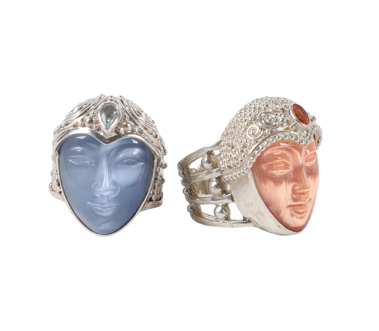 (2) Sajen Studio Sterling Silver Goddess Rings: Two Art Deco Style Sterling Silver Statement Rings, with carved moonstone faces wrapped in silver scarves and having a faceted semiprecious stone as a brooch. Blue measures size 7, coral measures 8.