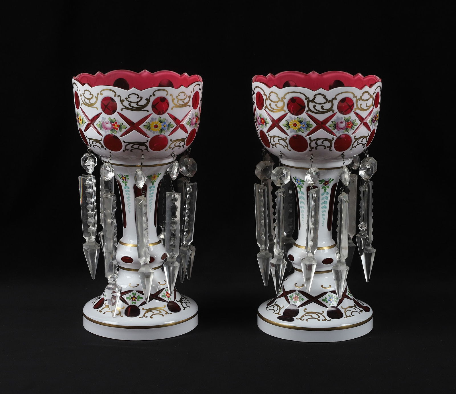 Bohemian White Overlay Cranberry Mantle Lusters: Pair of Bohemian White Overlay Cranberry Mantle Lusters., enamel decorated floral highlights, each with 10 hanging prisms, 11.75" h., 6" dia.