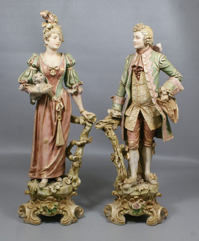 Pr Royal Dux Bohemia matte finished porcelain: Pr Royal Dux Bohemia matte finished porcelain figurines, elegant lady holding a small dog and a dandy gentleman, tallest 18 1/2", triangular applied mark, numbered 88 & 89, rose petal chipped at base