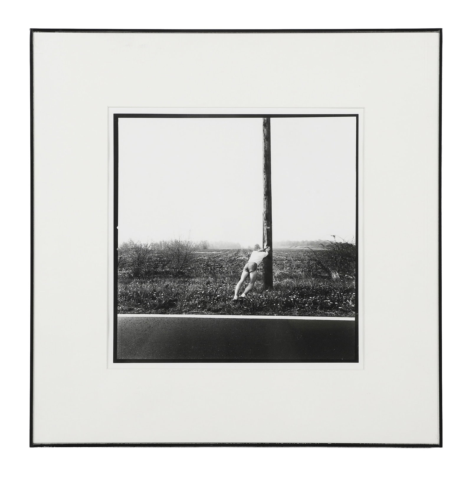 Poppleton, Eric: Eric Poppleton Untitled, 1985 Gelatin silver print Depicting Runner stretching roadside against a telephone pole. Framed under glass. Image Height: 11 in, Image Width: 14 in, Framed Height: 20 in, Fra
