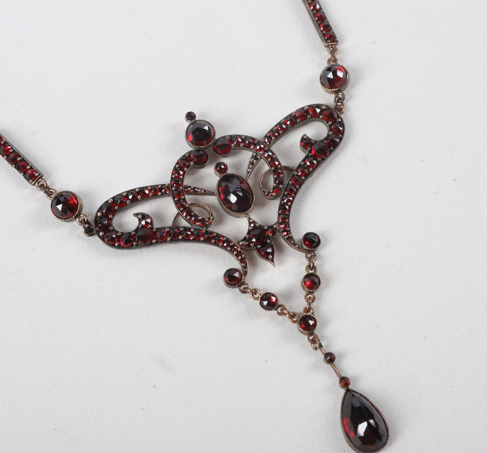 Bohemian Style Garnet Necklace: Bohemian Style Garnet Necklace Bohemian Style garnet necklace, rose cut garnets in a scrolling design attached to tear drop pendant, marked "JK" on clasp, 9" long, does not test for silver