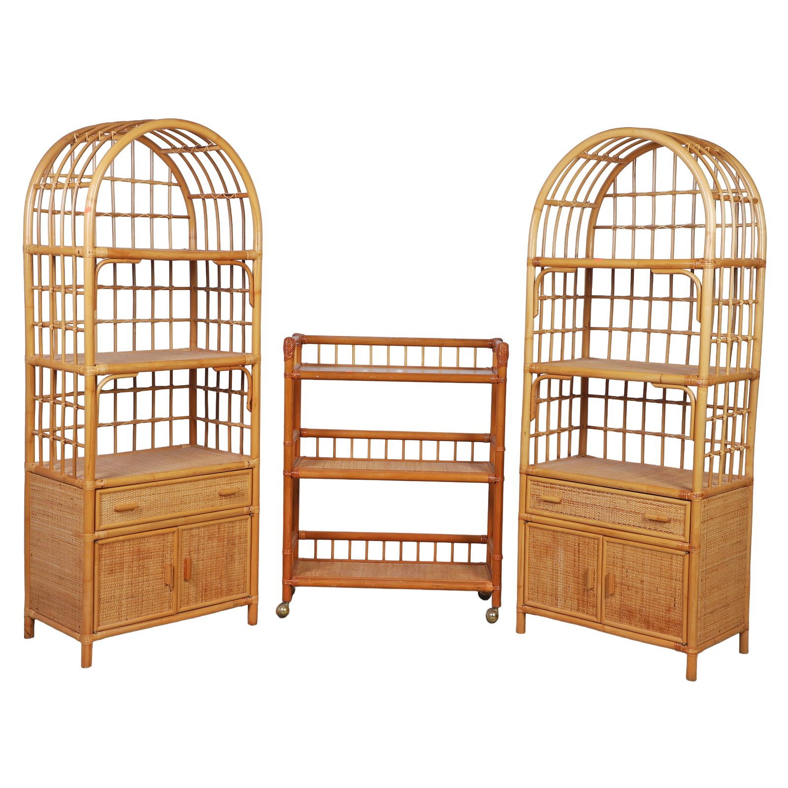 (3) Pc Wicker and Rattan Suite: (3) Pc Wicker and Rattan Suite c/o of (2) Arch top etegeres with cabinet bases, 66" H x 25" W x 16" D, and a castered 3 tiered book cart, 38.5" H x 30" W x 12" D.