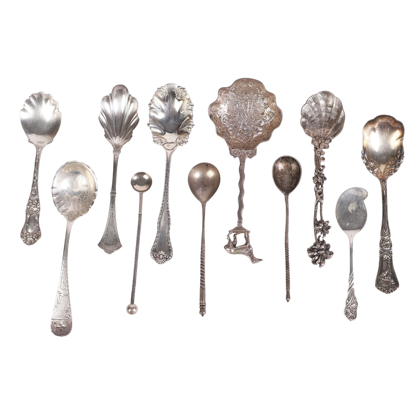 (11) Silver Shell Spoons: (11) Silver Shell Spoons (11) Silver shell spoons in a variety of designs with some sterling. Includes a pierced Dutch silver scene spoon, an 800 silver monkey spoon and more. Total weighable 3.450 oz