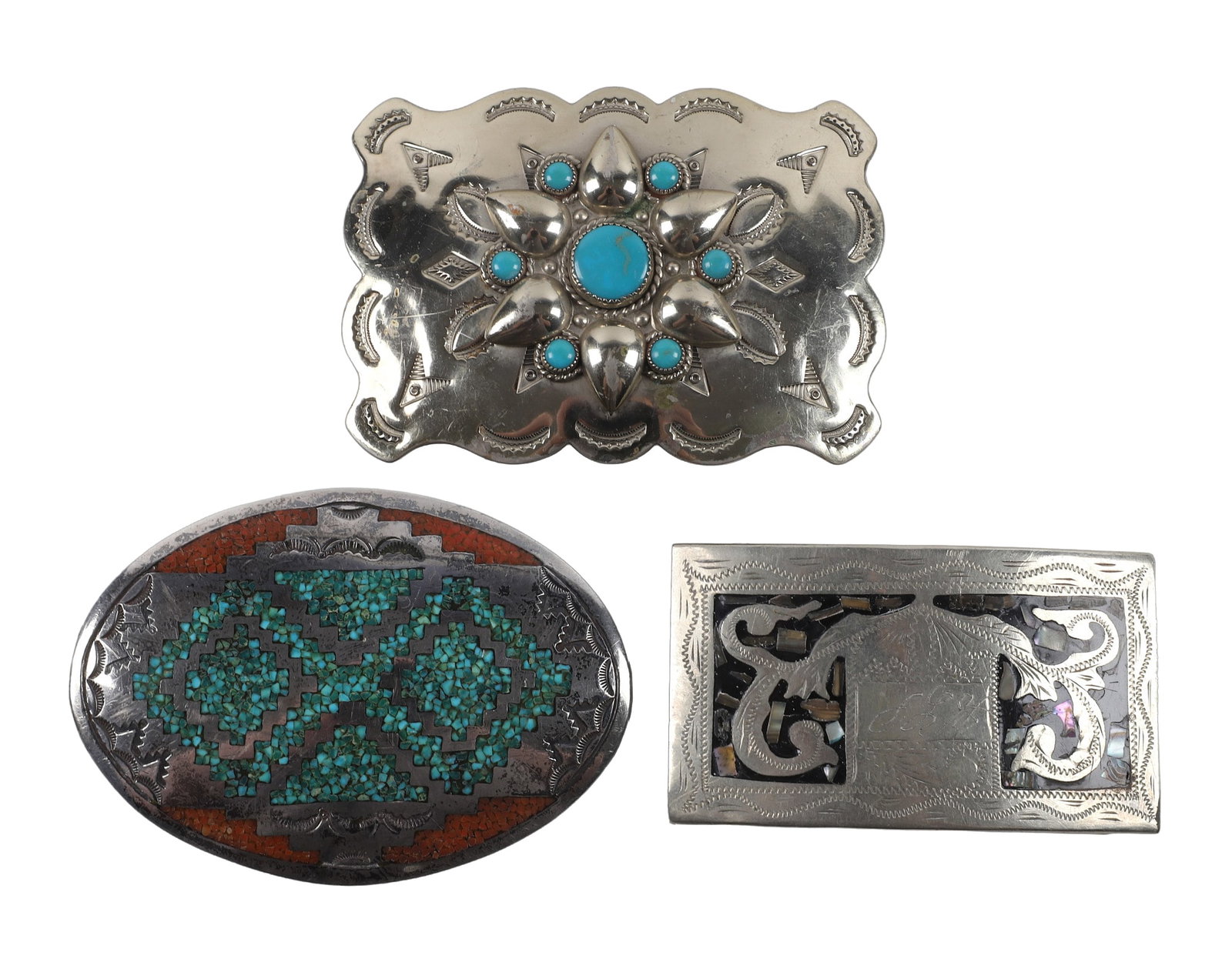 Three Vintage Southwest Style Belt Buckles.: Three Vintage Southwest Style Belt Buckles. Including a geometric mosaic inlay oval buckle marked "FO", 3 11/16" w., a scalloped edge faux turquoise cluster buckle. marked "Nickel Silver Bell" (Bell