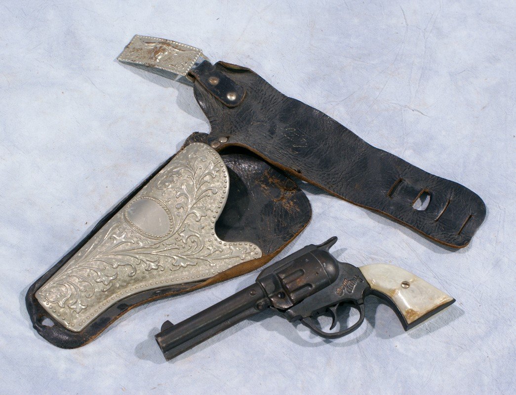 Gene Autry cast iron cap gun with leather & metal: Gene Autry cast iron cap gun with leather & metal holster and partial belt with buckle, damage to butt