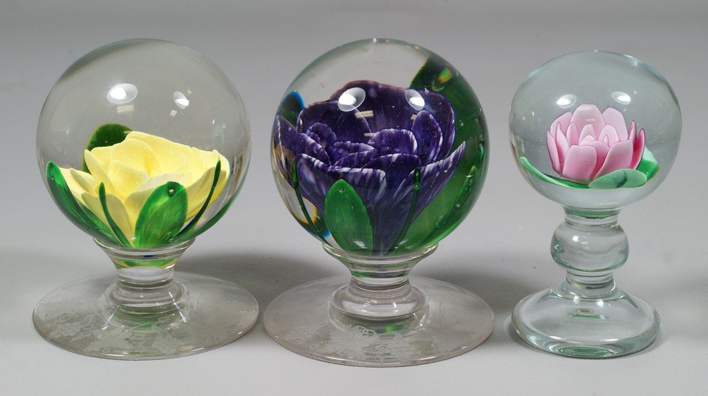 (2) Pairpoint pedestal form floral paperweights, yellow: (2) Pairpoint pedestal form floral paperweights, yellow and violet, with grapevine engraved bases, signed "P" at base, 4 1/2" tall, with a Robert Harmon pedestal floral paperweight signed "H", also 4 