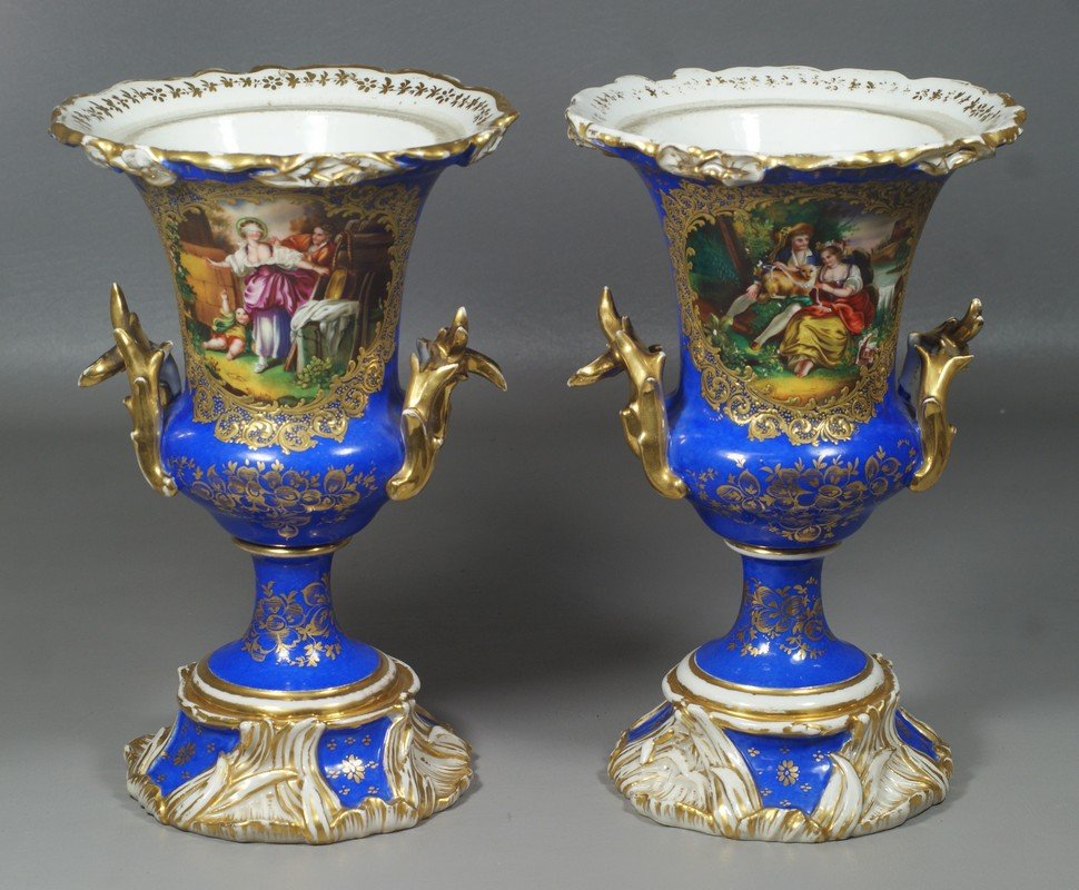 Pair of Continental Urns, probably Paris Porcelain,: Pair of Continental Urns, probably Paris Porcelain, decorated in Cobalt Blue with painted bucolic reserves, one a romantic scene, the other "Blind Man's Bluff", minor wear to gilding, one prong of one