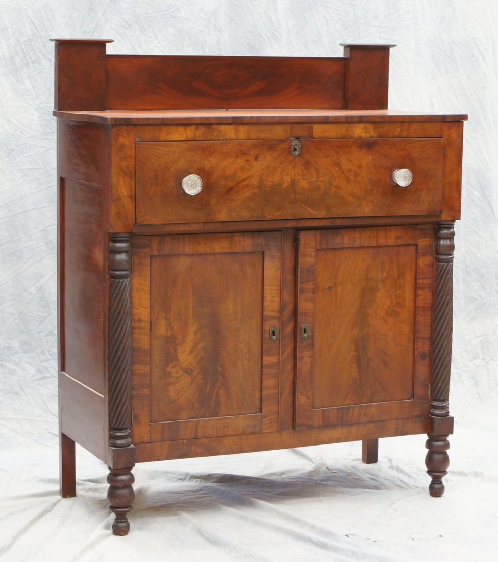 Sheraton crotch mahogany chest, one drawer with brass: Sheraton crotch mahogany chest, one drawer with brass pulls over 2 doors with brass escutcheons, with applied half barley twist columns and pilaster style backsplash, 54 1/2" high, 44 1/2" wide, 20" d