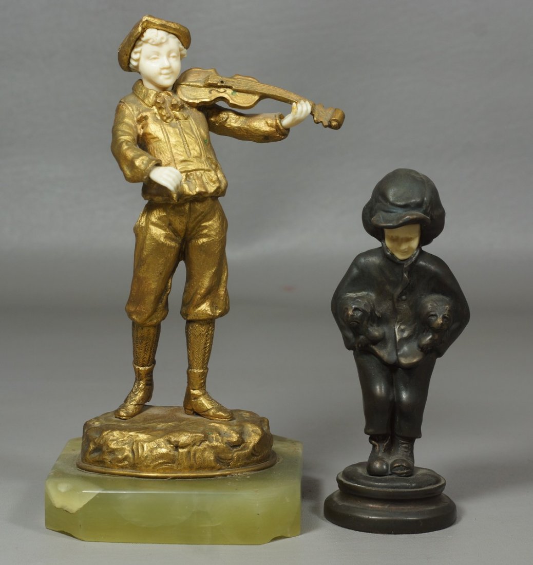 2 Figures with Ivory Faces, a violinist with onyx base,: 2 Figures with Ivory Faces, a violinist with onyx base, signed Ostrem, 8" high, together with a young boy with puppies, unsigned. We adhere strictly to all state and Federal laws pertaining to the sal