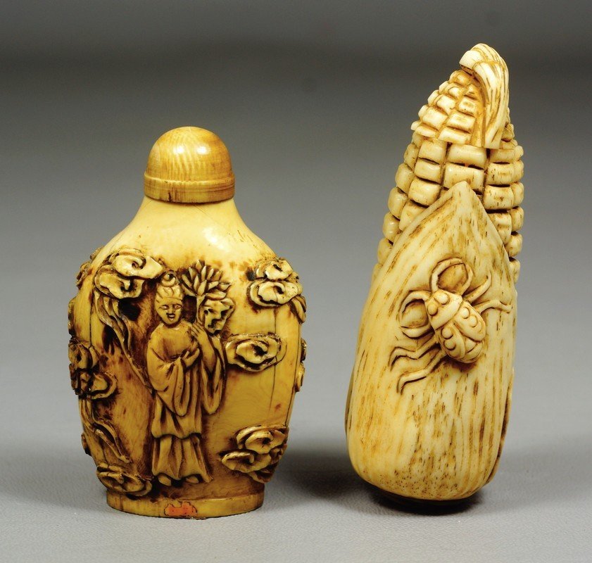 (2) carved ivory snuff bottles, one an ear of corn with: (2) carved ivory snuff bottles, one an ear of corn with a bug, 3 3/8" h, the other with figural and lotus carving, missing spoon on stopper, 2 3/4" h. We adhere strictly to all state and Federal laws 
