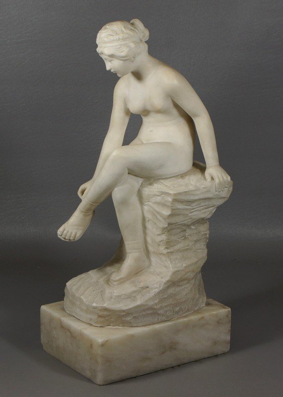 Carved alabaster figure of a seated nude woman: Carved alabaster figure of a seated nude woman adjusting her sandal, 16" tall