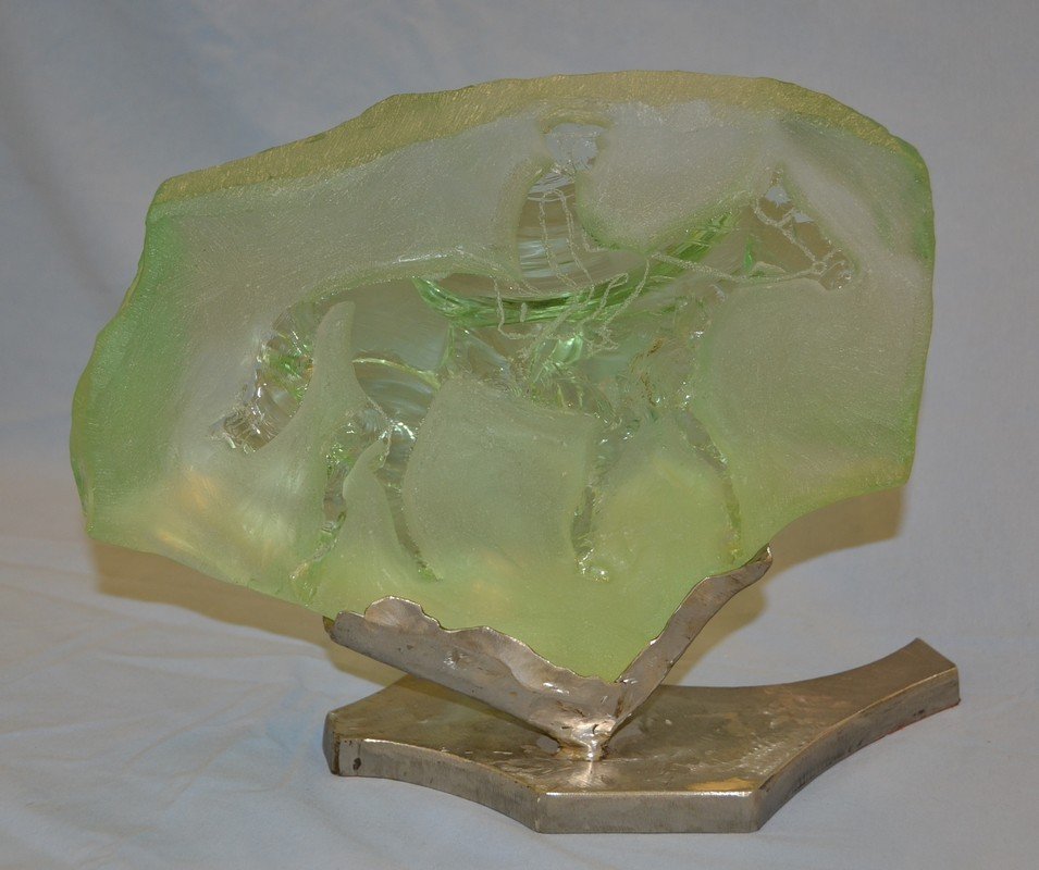 Aqua crystal sculpture of a horse and rider on a welded: Aqua crystal sculpture of a horse and rider on a welded steel base, titled "Out of The Paddock," no other identifying marks, 11" high, 13" wide.