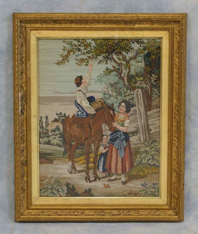Needlepoint panel depicting Young Man Picking Fruit: Needlepoint panel depicting Young Man Picking Fruit from Horseback, good gilt frame, 33" x 27"