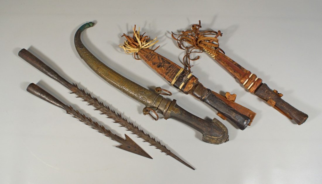 2 wrought iron barbed spear points, longest 16 3/4",: 2 wrought iron barbed spear points, longest 16 3/4", with a curved knife in a brass scabbard, 15" overall, and 2 more wood handled knives in leather scabbards, African,