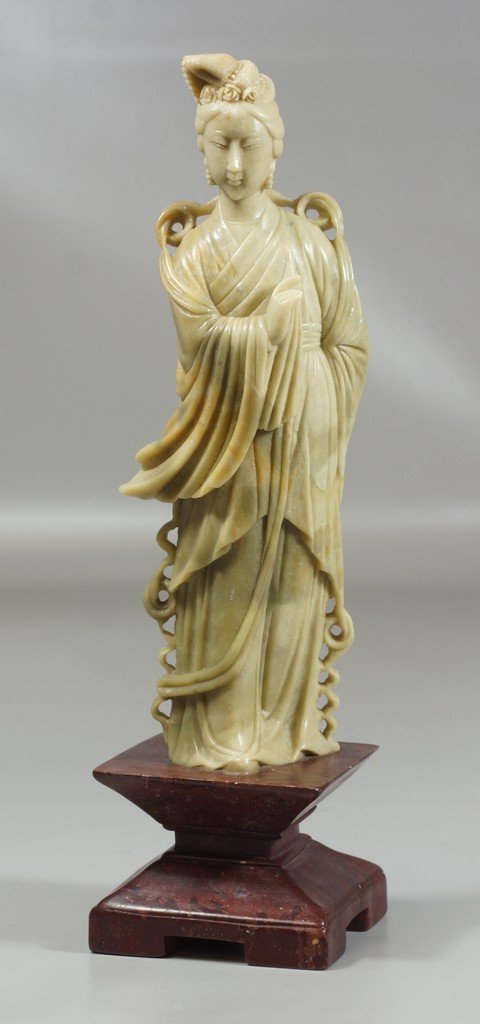 Carved pale green soapstone female figure on red stone: Carved pale green soapstone female figure on red stone base, 14" tall, tips of 2 fingers with losses