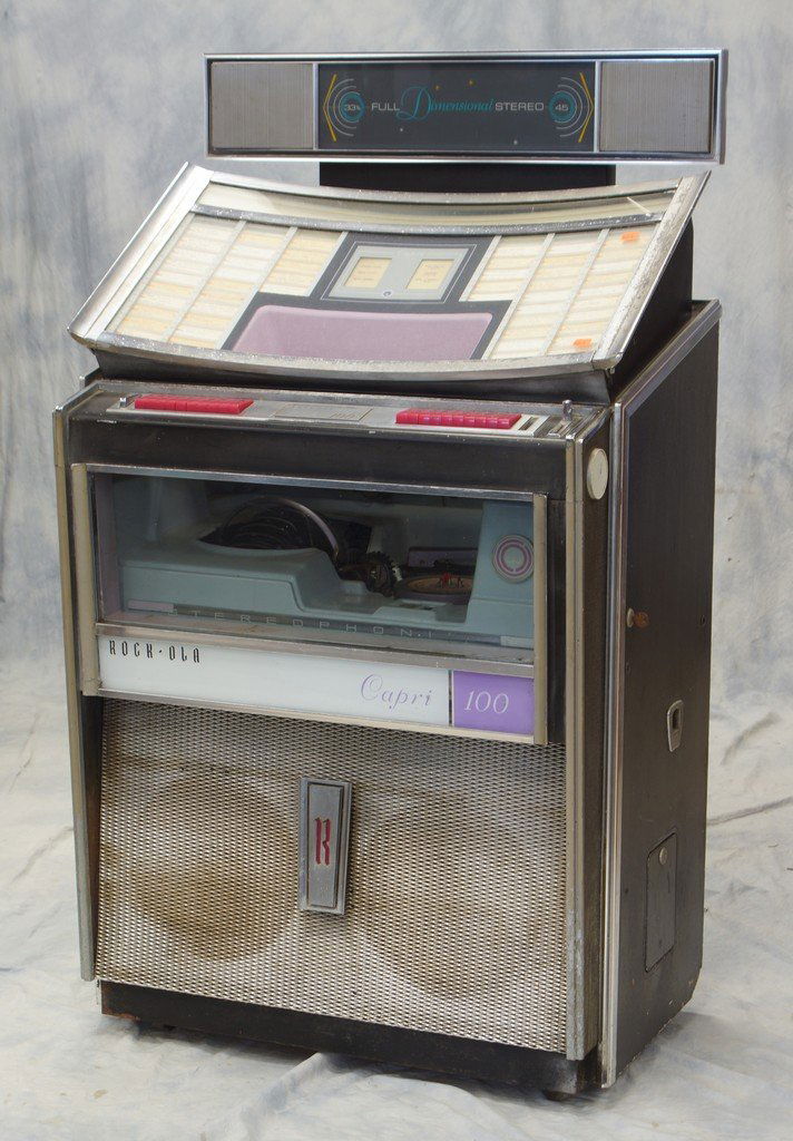 "Rock-Ola 100" jukebox, plays 33-1/2/45, full: "Rock-Ola 100" jukebox, plays 33-1/2/45, full dimensional stereo, 55-1/2" h x 32" w x 23" d