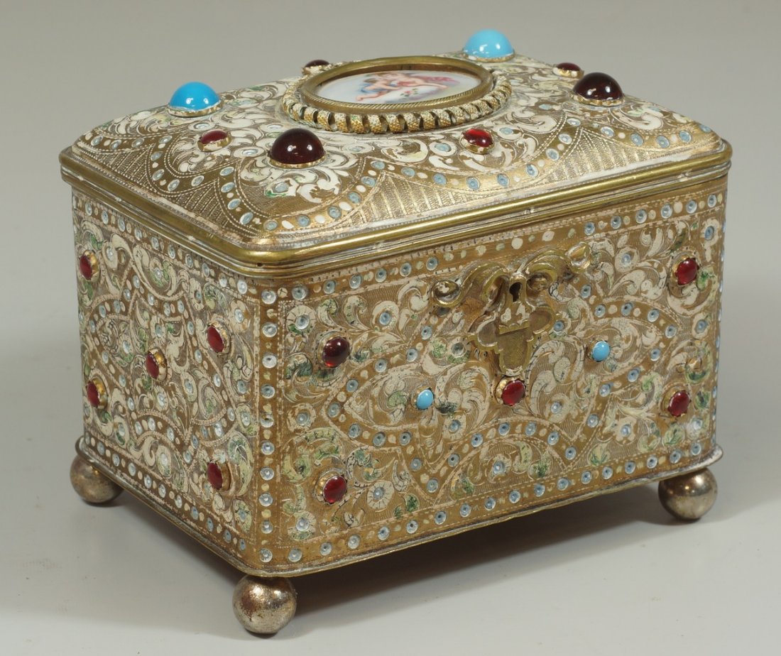 Continental brass dresser box, top set with oval: Continental brass dresser box, top set with oval painted porcelain plaque with cherubs, overall set with turquoise and red stones, appears to be missing enameled jewels throughout, 7" w, 6" h