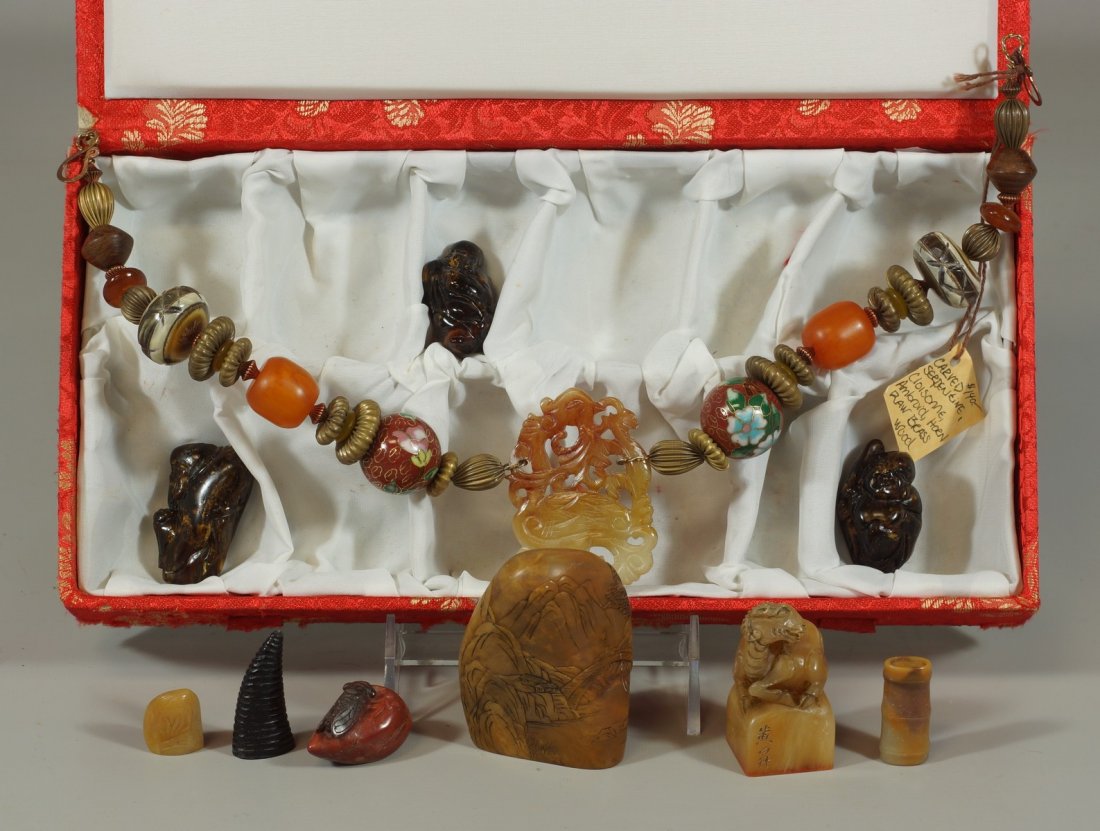 9 Chinese carvings and a necklace to include 2: 9 Chinese carvings and a necklace to include 2 soapstone seals, 3 amber-like carvings and assorted hardstone carvings, with a divided box