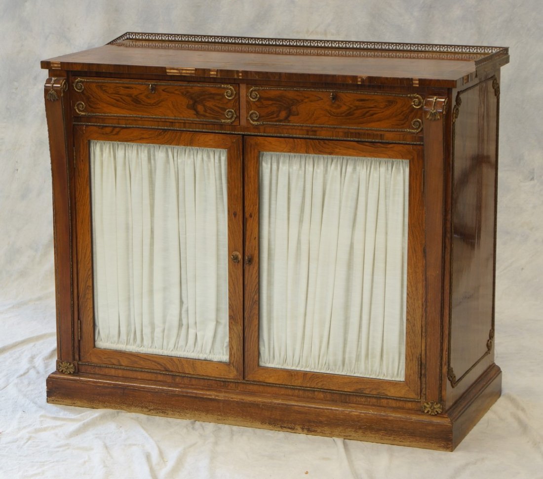 Brass inlaid and ormolu mounted rosewood Regency style: Brass inlaid and ormolu mounted rosewood Regency style credenza with beveled glass doors under 2 drawers, veneer losses to edges, 42" w, 20" d, 35" h, late 19th/early 20th century