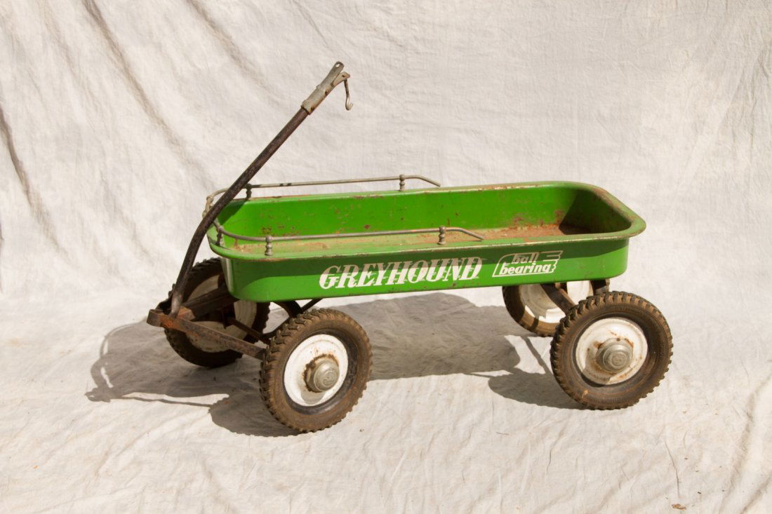 Greyhound pressed steel wagon; green with ball bearing: Greyhound pressed steel wagon; green with ball bearing track and metal surround (surface rust, missing handle) 16-1/2h x 17"w x 42"l