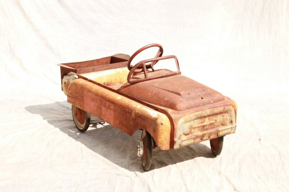 Hydraulic dump truck pressed steel pedal car; working: Hydraulic dump truck pressed steel pedal car; working dump hopper on back (lots of surface rust, back dumper dented) 19-1/2"h x 40"l x 18"w