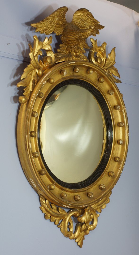 Federal gilded convex mirror, surmounted by an eagle: Federal gilded convex mirror, surmounted by an eagle flanked by pierced foliage, above a circular mirror plate, approxiamtely 42" high, 25" wide.