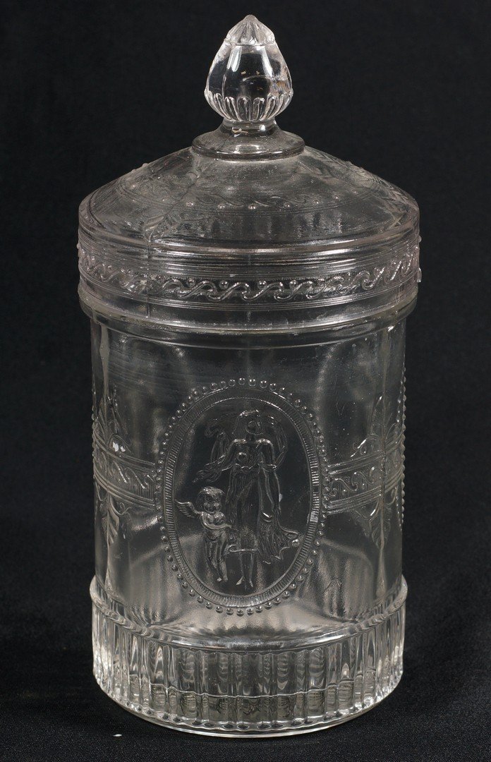 American pressed glass pickle jar, "Cupid and Venus",: American pressed glass pickle jar, "Cupid and Venus", approximately 7" high, chip at interior rim, some roughness at base
