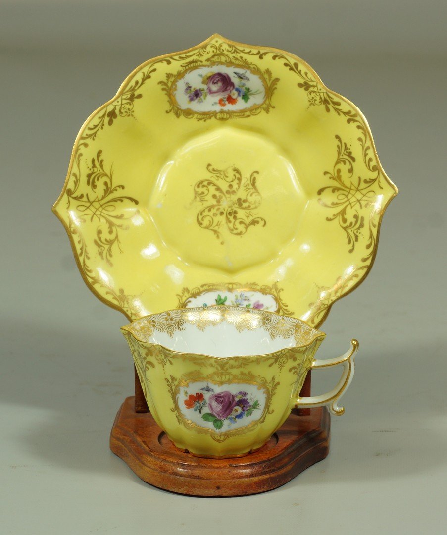 Yellow Meissen scalloped Rococo style cup & saucer with: Yellow Meissen scalloped Rococo style cup & saucer with handpainted floral decoration & gilt trim, with blue crossed sword mark of first quality, saucer 5 1/8" dia, cup 2 1/8" h