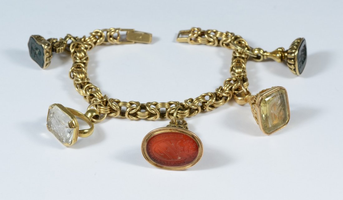 14K YG charm bracelet, with 5 watch fobs, all set with: 14K YG charm bracelet, with 5 watch fobs, all set with intaglio carved colored stones, all unmarked, but test as 14K, 59.0 dwt
