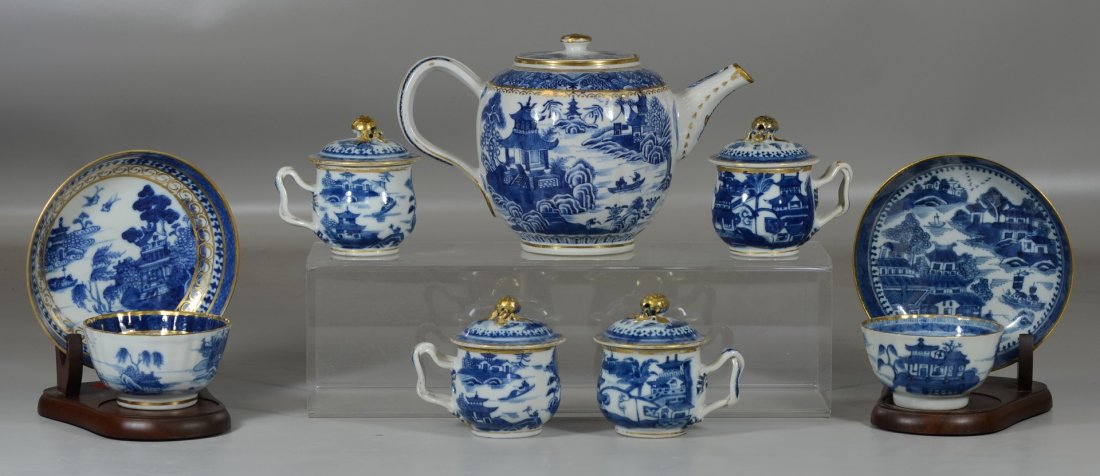 9 Pieces of Chinese Export Nanking Pattern, most: 9 Pieces of Chinese Export Nanking Pattern, most covered clobbered with gold, consisting of a teapot, 4 pots de crème (with lids), 2 cups and saucers, together with 2 wooden stands, teapot measures 5
