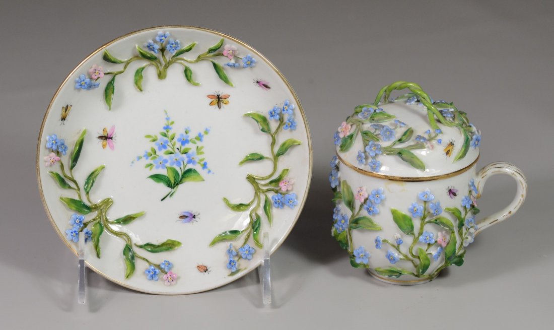 Meissen style porcelain covered chocolate cup and: Meissen style porcelain covered chocolate cup and saucer with applied floral decoration, bottom with a blue overglaze crossed line mark, saucer 5 1/2" d, cup 4" high, c 1900, Meissen style porcelain c