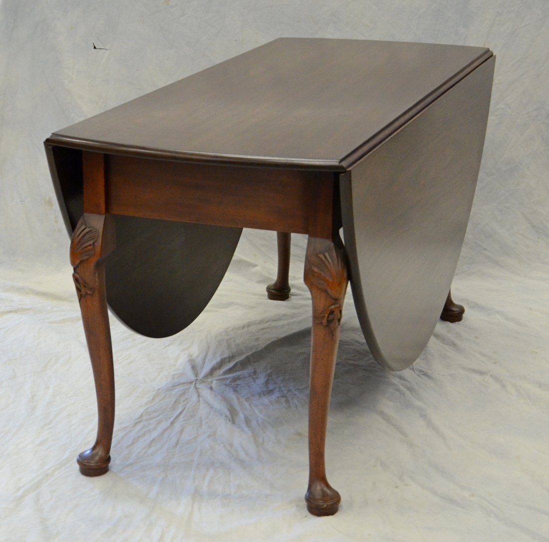 Kittinger mahogany Queen Anne style drop leaf dining: Kittinger mahogany Queen Anne style drop leaf dining table with swing leg support, semi-circular leaves, paper label pattern no CW117, 58" l x 24" w, 23-1/2" leaves, dimensions when opened 70" x 58"