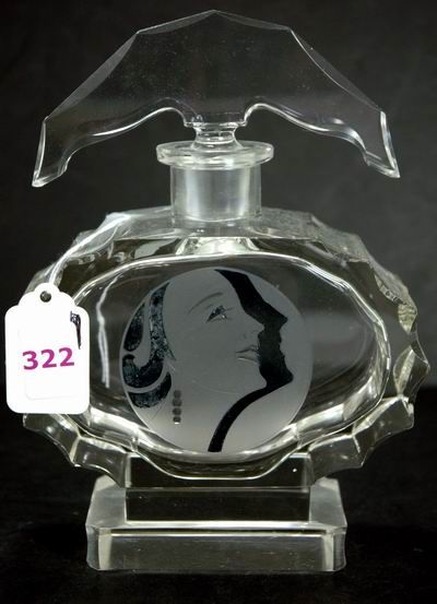 GREAT PORTRAIT DECO COLOGNE BOTTLE: A cut and beveled crystal cologne acid stamped Made in Czechoslovakia on the base. Oval body on retangular base and a superb arched stopper. Front has deco portrait with shadow behind. 7 1/2 inches to