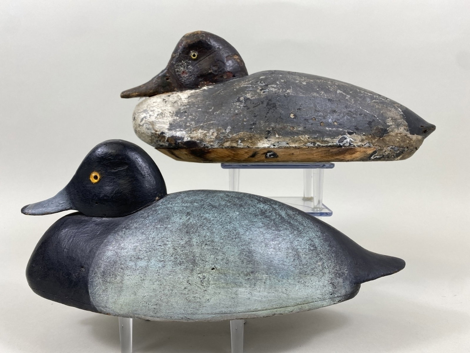2 Early Michigan Low Head Duck Decoys: 1 goldeneye hen by unknown St. Clair Flats carver, old working paint, gunning wear, a few shot marks & 1 bluebill drake by unknown St. Clair Flats carver in the style of Chris Smith, Algonac, MI, rest