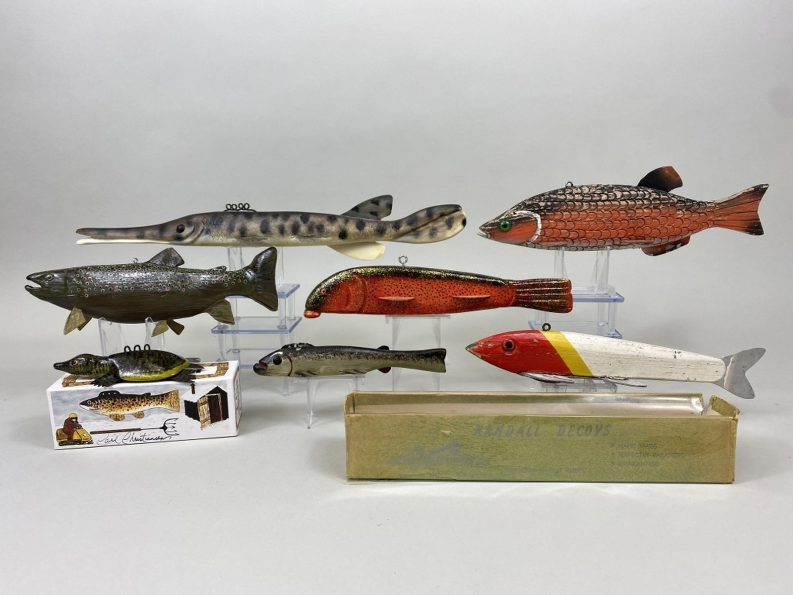 7 Fish Spearing Decoys: various species & makers including a Carl Christiansen spiny softshell turtle in the original box, excellent condition, "CC" on bottom, 1 Randall red & white in original box, fair condition, 1 Kim Cro