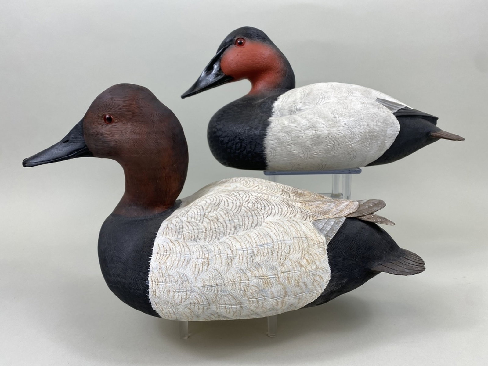 2 Decorative Canvasback Drake Duck Decoys: 1 by Andrew W. Spur, Jr., wooden decoy, raised crossed wings, near mint, "Blue Mountain Carving" brand, signed & dated Dec. 2003 & 1 by J. Bundy, made of cast resin, signed & numbered, Both have glass