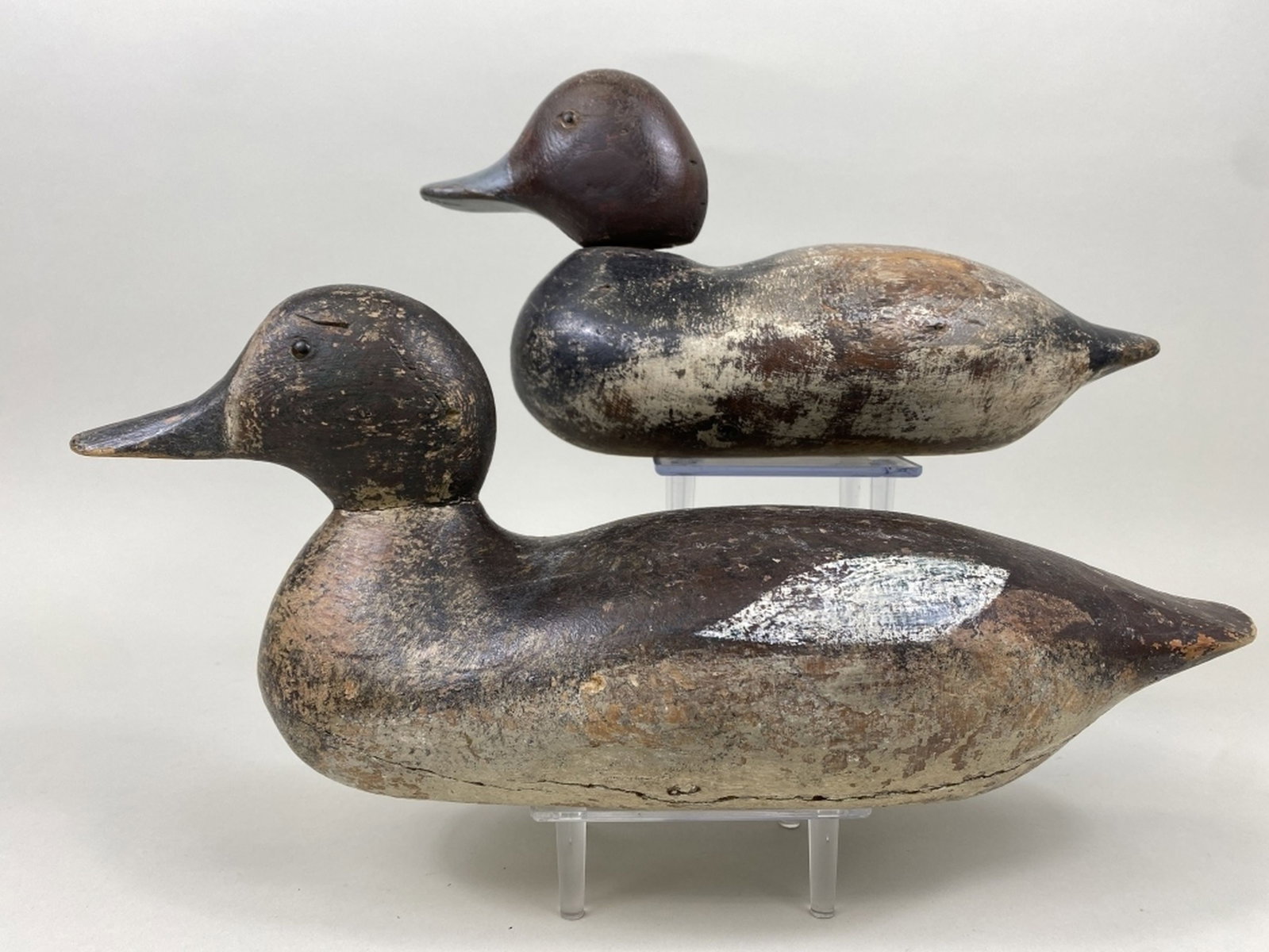 2 Mason Duck Decoys: Detroit, MI, standard grade, 1 redhead drake & 1 bluebill hen, glass eyes, solid bodies, combination of original & old working paint, shot marks & gunning wear, drake has age cracks, neck filler missi