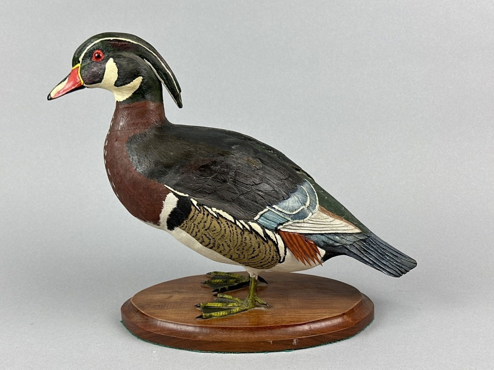 Hand Carved Standing Wood Duck Drake: by unknown carver, glass eyes, solid body, excellent original paint, detailed feather carving, tight age crack in back, missing some detail on right side, great form, mounted on wooden base, 11"T, est